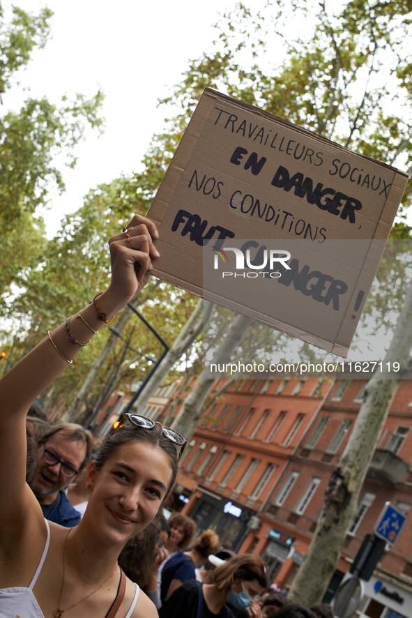 A protester holds a placard reading 'social workers in danger, change our work situations'. Between 3,000 and 5,000 protesters march in Toul...