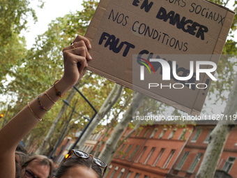 A protester holds a placard reading 'social workers in danger, change our work situations'. Between 3,000 and 5,000 protesters march in Toul...