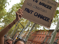 A protester holds a placard reading 'social workers in danger, change our work situations'. Between 3,000 and 5,000 protesters march in Toul...