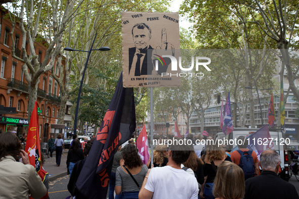 A man holds a placard depicting Macron and reading 'one piss on you and you believe it's rain'. Between 3,000 and 5,000 protesters march in...