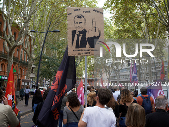 A man holds a placard depicting Macron and reading 'one piss on you and you believe it's rain'. Between 3,000 and 5,000 protesters march in...