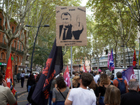 A man holds a placard depicting Macron and reading 'one piss on you and you believe it's rain'. Between 3,000 and 5,000 protesters march in...