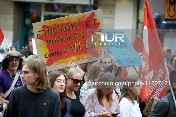 A protester holds a cardboard sign reading 'students and workers united against a costly life'. Between 3,000 and 5,000 protesters march in...