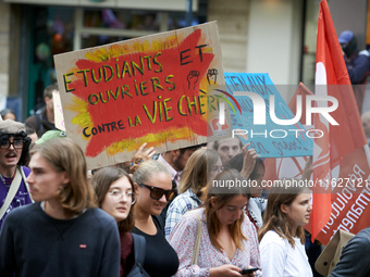 A protester holds a cardboard sign reading 'students and workers united against a costly life'. Between 3,000 and 5,000 protesters march in...