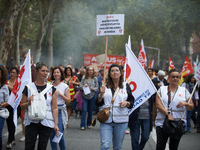 A woman walks with a placard reading 'Stop! We refuse to be exploited for a starvation salary'. Between 3,000 and 5,000 protesters march in...