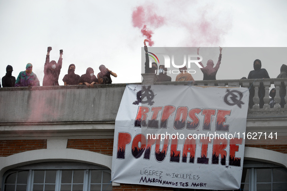 People on the roof display a banner reading 'Popular response'. Between 3,000 and 5,000 protesters march in Toulouse, France, on October 1,...