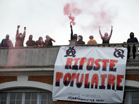 People on the roof display a banner reading 'Popular response'. Between 3,000 and 5,000 protesters march in Toulouse, France, on October 1,...