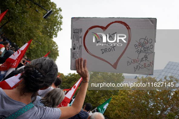 A protester holds a placard reading 'State of Law'. Between 3,000 and 5,000 protesters march in Toulouse, France, on October 1, 2024, called...