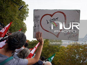 A protester holds a placard reading 'State of Law'. Between 3,000 and 5,000 protesters march in Toulouse, France, on October 1, 2024, called...