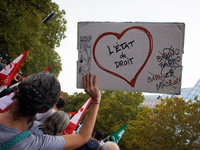 A protester holds a placard reading 'State of Law'. Between 3,000 and 5,000 protesters march in Toulouse, France, on October 1, 2024, called...