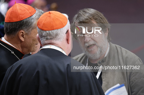 Luca Casarini, head of Mission of Mediterranea Saving Humans, talks with two cardinals before the vigil prayer in St. Peter's Basilica ahead...