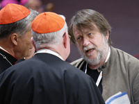 Luca Casarini, head of Mission of Mediterranea Saving Humans, talks with two cardinals before the vigil prayer in St. Peter's Basilica ahead...