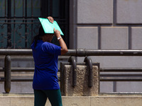 Pedestrians protect themselves from the intense heat in the central region of Sao Paulo, Brazil, on October 1, 2024. (