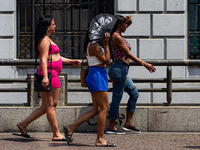 Pedestrians protect themselves from the intense heat in the central region of Sao Paulo, Brazil, on October 1, 2024. (