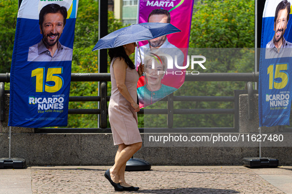 Pedestrians protect themselves from the intense heat in the central region of Sao Paulo, Brazil, on October 1, 2024. 