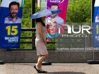 Pedestrians protect themselves from the intense heat in the central region of Sao Paulo, Brazil, on October 1, 2024. (