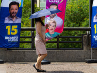 Pedestrians protect themselves from the intense heat in the central region of Sao Paulo, Brazil, on October 1, 2024. (