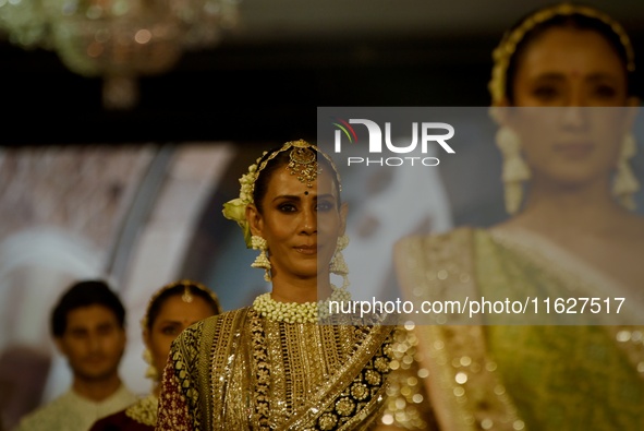 Models present a creation by Indian designer Manish Malhotra to showcase the Handloom Indian Couture collection during a charity event to su...