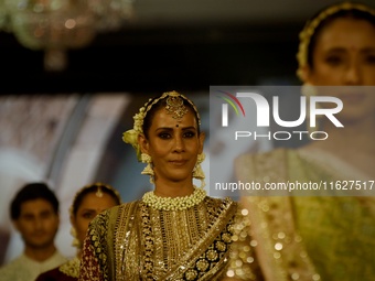 Models present a creation by Indian designer Manish Malhotra to showcase the Handloom Indian Couture collection during a charity event to su...