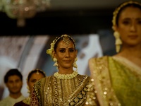 Models present a creation by Indian designer Manish Malhotra to showcase the Handloom Indian Couture collection during a charity event to su...