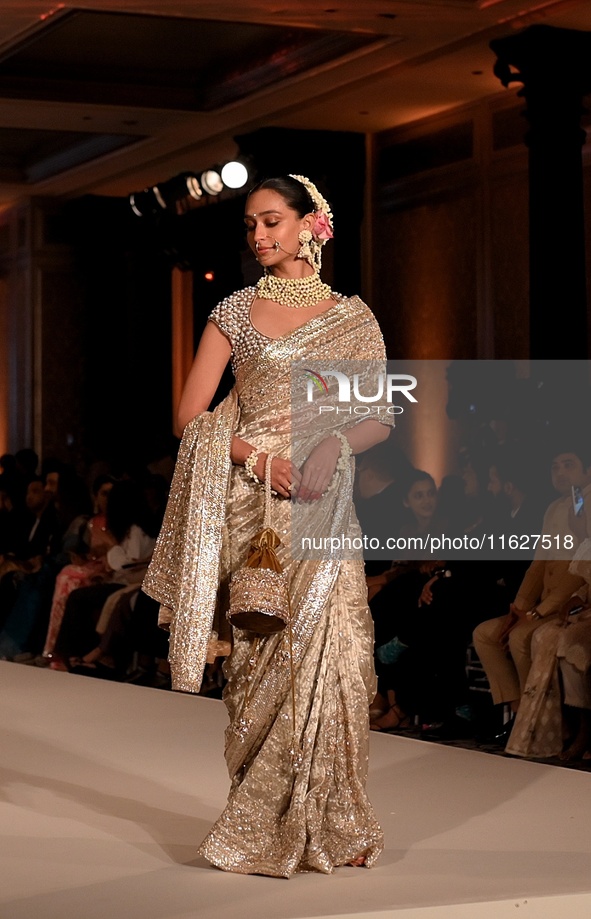 Models present a creation by Indian designer Manish Malhotra to showcase the Handloom Indian Couture collection during a charity event to su...