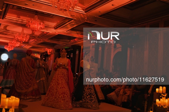 Models present a creation by Indian designer Manish Malhotra to showcase the Handloom Indian Couture collection during a charity event to su...