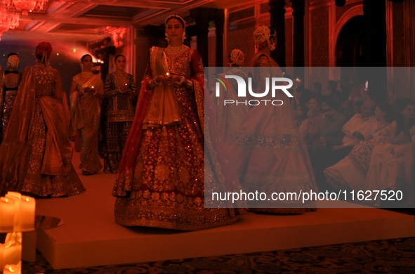 Models present a creation by Indian designer Manish Malhotra to showcase the Handloom Indian Couture collection during a charity event to su...