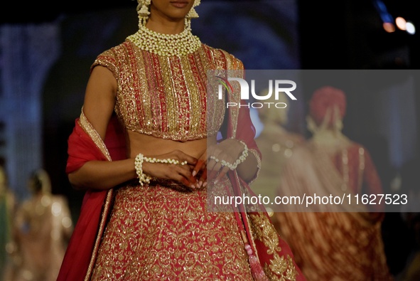 Models present a creation by Indian designer Manish Malhotra to showcase the Handloom Indian Couture collection during a charity event to su...