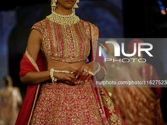 Models present a creation by Indian designer Manish Malhotra to showcase the Handloom Indian Couture collection during a charity event to su...