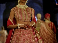 Models present a creation by Indian designer Manish Malhotra to showcase the Handloom Indian Couture collection during a charity event to su...