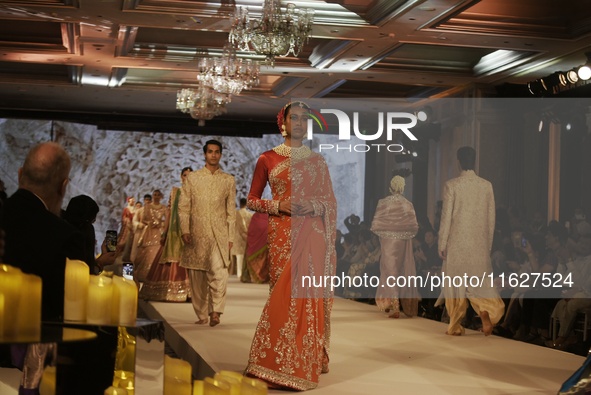 Models present a creation by Indian designer Manish Malhotra to showcase the Handloom Indian Couture collection during a charity event to su...