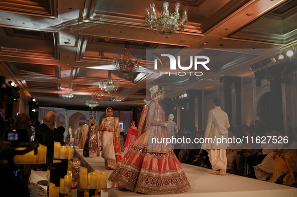 Models present a creation by Indian designer Manish Malhotra to showcase the Handloom Indian Couture collection during a charity event to su...