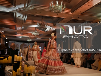 Models present a creation by Indian designer Manish Malhotra to showcase the Handloom Indian Couture collection during a charity event to su...