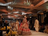 Models present a creation by Indian designer Manish Malhotra to showcase the Handloom Indian Couture collection during a charity event to su...