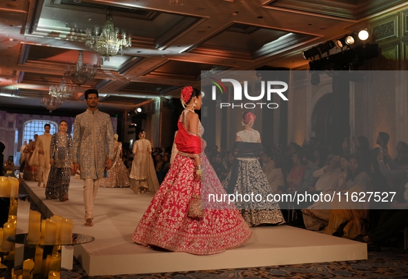 Models present a creation by Indian designer Manish Malhotra to showcase the Handloom Indian Couture collection during a charity event to su...