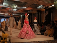 Models present a creation by Indian designer Manish Malhotra to showcase the Handloom Indian Couture collection during a charity event to su...