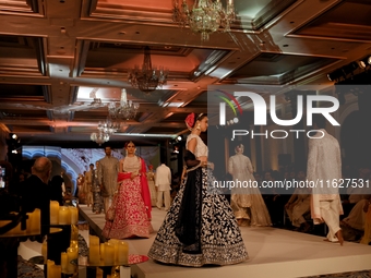 Models present a creation by Indian designer Manish Malhotra to showcase the Handloom Indian Couture collection during a charity event to su...