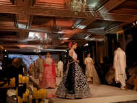 Models present a creation by Indian designer Manish Malhotra to showcase the Handloom Indian Couture collection during a charity event to su...