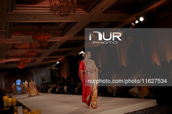 Models present a creation by Indian designer Manish Malhotra to showcase the Handloom Indian Couture collection during a charity event to su...