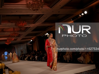 Models present a creation by Indian designer Manish Malhotra to showcase the Handloom Indian Couture collection during a charity event to su...