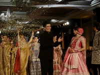 Indian designer Manish Malhotra (L), Bollywood actors Tripti Dimri (C) and Kartik Aryan (R) present a creation by Indian designer Manish Mal...