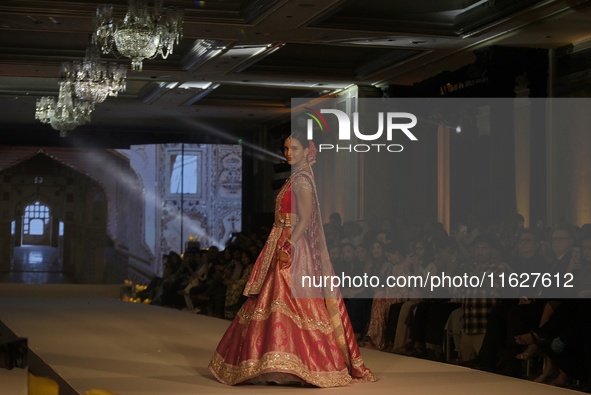 Bollywood actress Tripti Dimri presents a creation by Indian designer Manish Malhotra to showcase the Handloom Indian Couture collection dur...