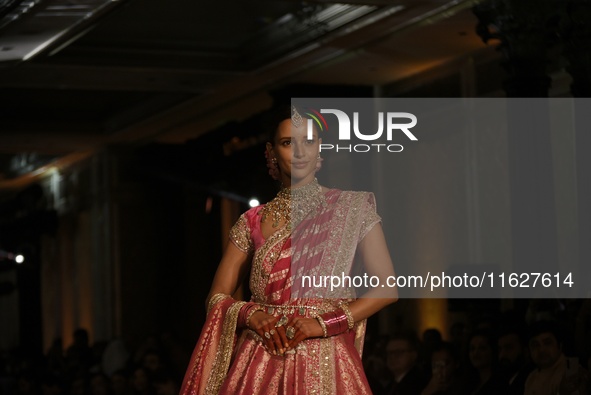 Bollywood actress Tripti Dimri presents a creation by Indian designer Manish Malhotra to showcase the Handloom Indian Couture collection dur...