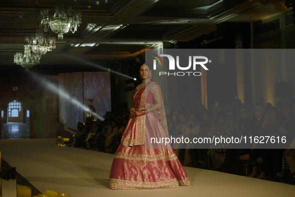 Bollywood actress Tripti Dimri presents a creation by Indian designer Manish Malhotra to showcase the Handloom Indian Couture collection dur...