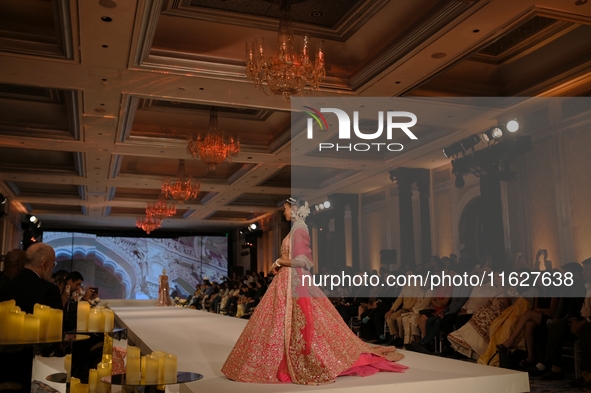 A model presents a creation by Indian designer Manish Malhotra to showcase the Handloom Indian Couture collection during a charity event to...