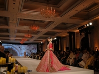 A model presents a creation by Indian designer Manish Malhotra to showcase the Handloom Indian Couture collection during a charity event to...