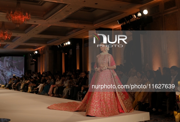 A model presents a creation by Indian designer Manish Malhotra to showcase the Handloom Indian Couture collection during a charity event to...