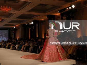 A model presents a creation by Indian designer Manish Malhotra to showcase the Handloom Indian Couture collection during a charity event to...