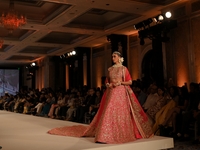 A model presents a creation by Indian designer Manish Malhotra to showcase the Handloom Indian Couture collection during a charity event to...