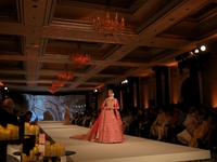 A model presents a creation by Indian designer Manish Malhotra to showcase the Handloom Indian Couture collection during a charity event to...